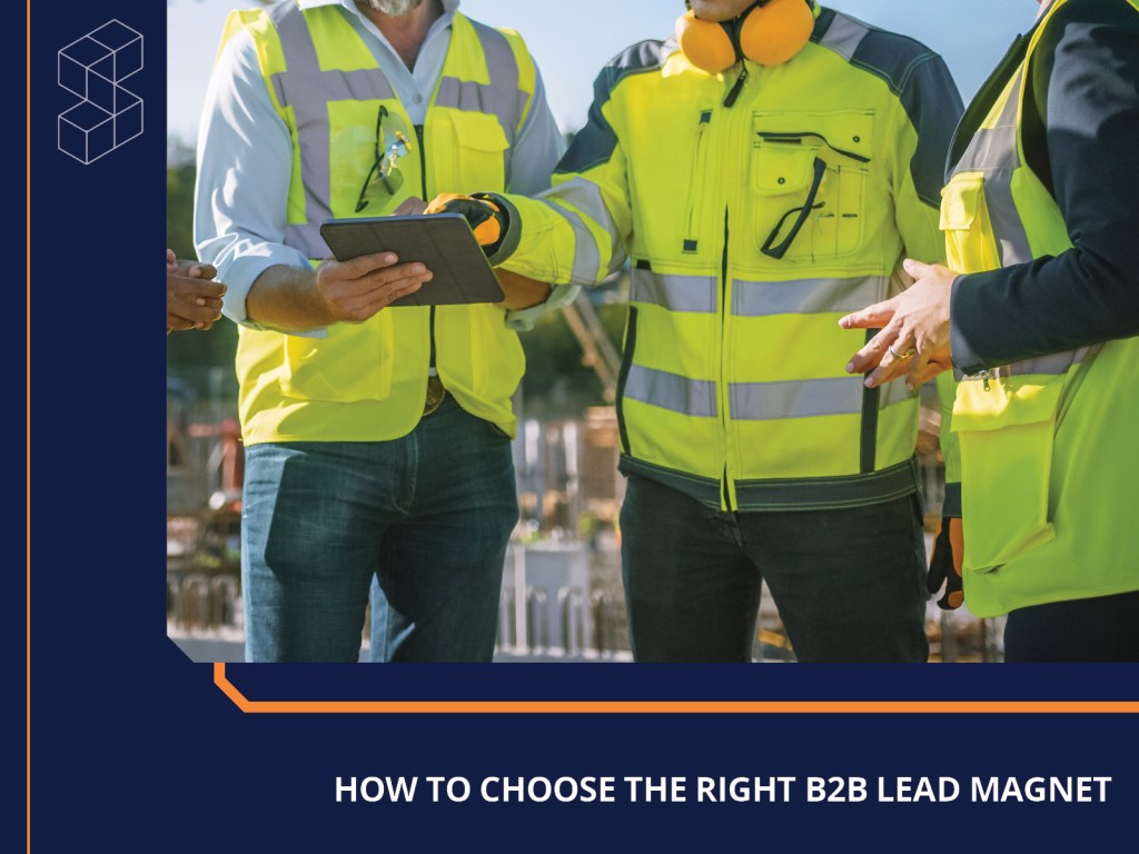 people in safety gear talking and pointing to a tablet